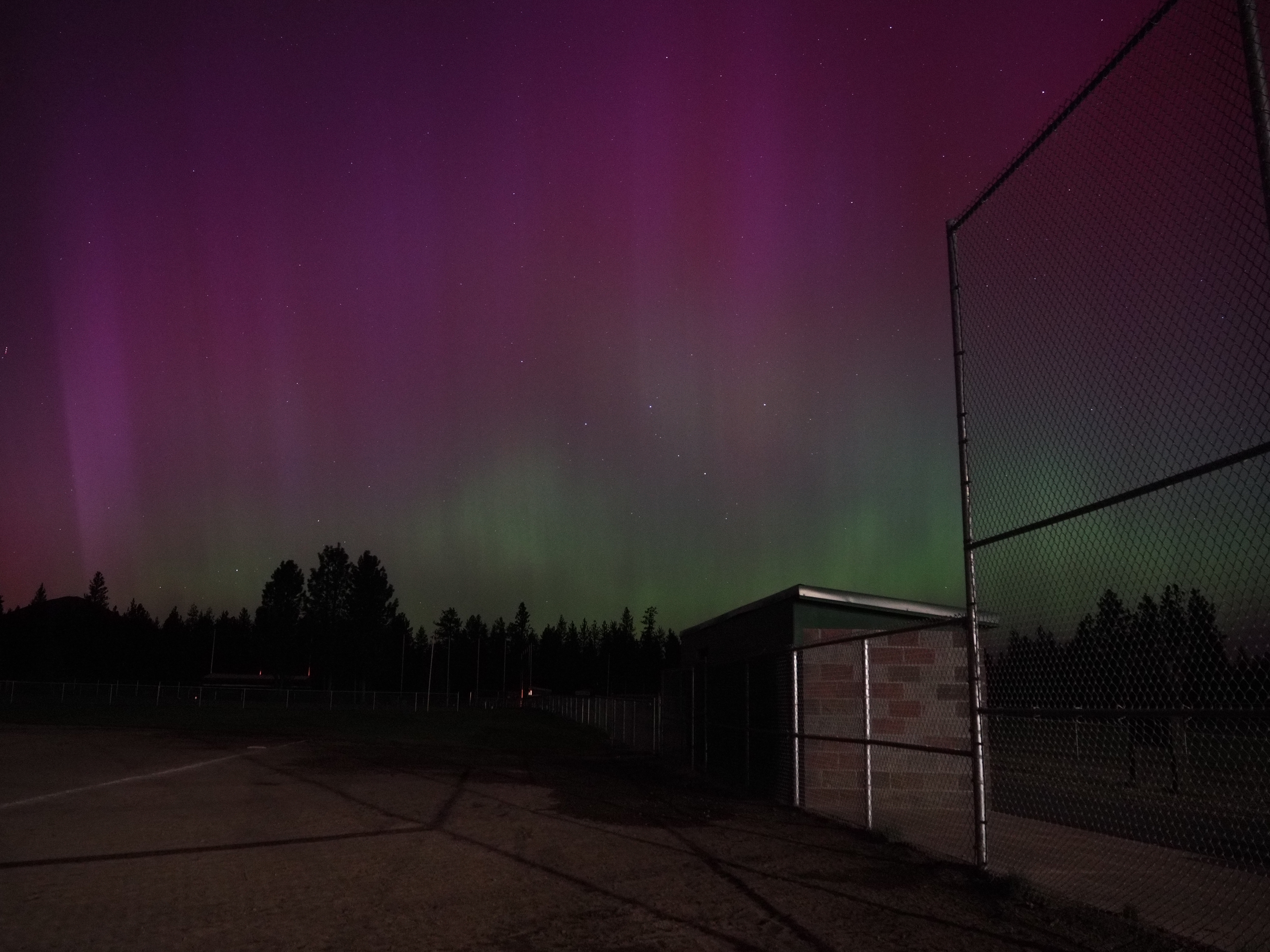 The aurora shot from home plate, softball dugout in the foreground